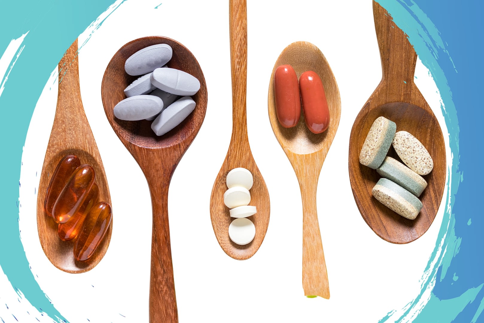 Multiple wooden spoons with different supplement pills in them.
